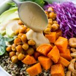Buddha Bowl con quinua, garbanzos, boniato, aguacate, repollo, vinagreta de tahini vertido