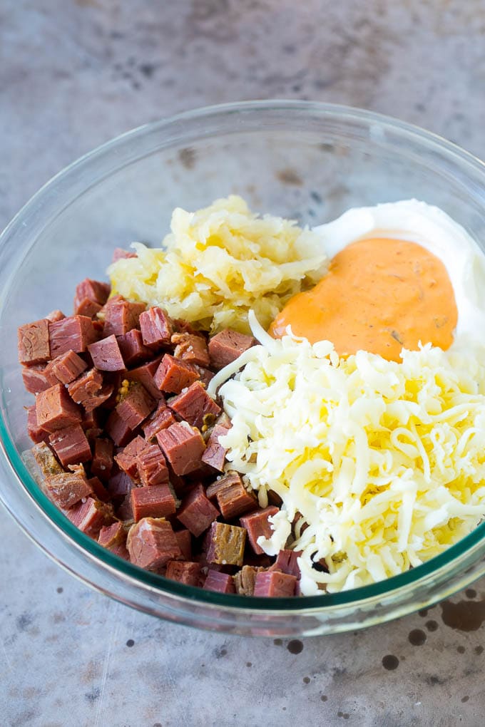 Carne enlatada, queso crema, aderezo Thousand Island y queso en un tazón.