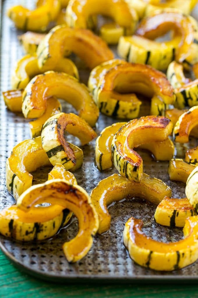 Una receta de calabaza delicada con calabaza asada con azúcar morena en una bandeja para hornear.