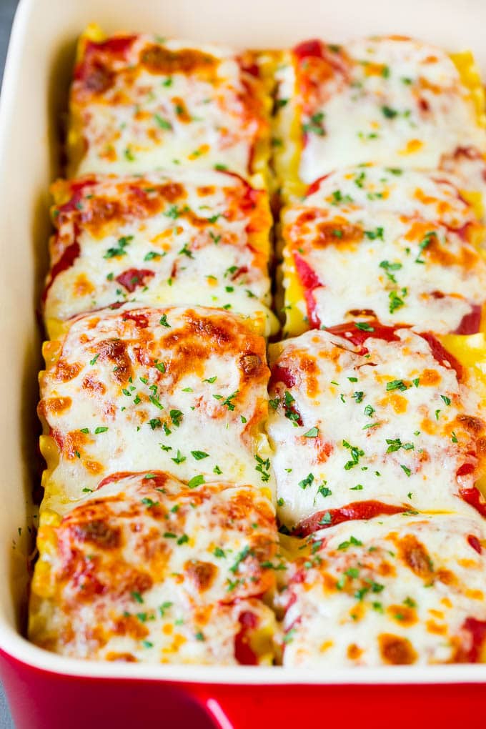Rollos de lasaña al horno cubiertos con mozzarella derretida.