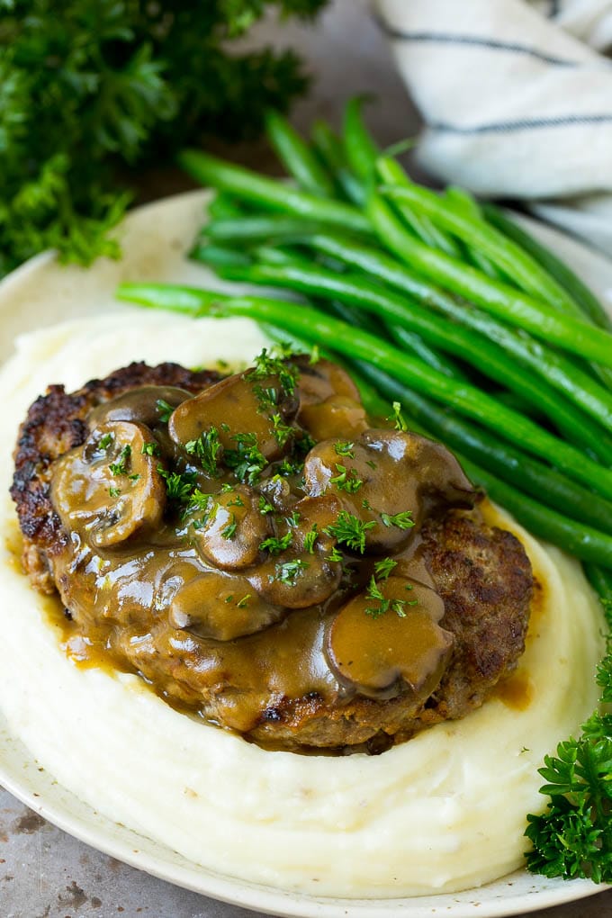 Bistec picado servido sobre puré de papas con judías verdes.