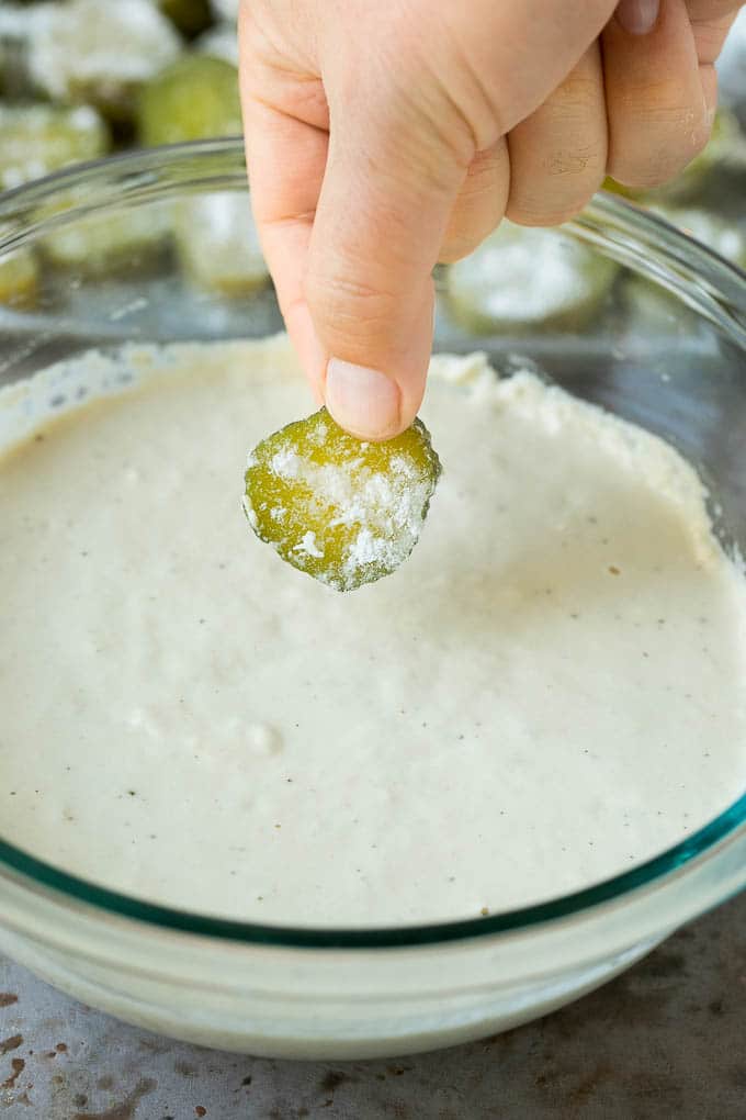 Una rodaja de pepinillo mojado en un cuenco de masa de cerveza.