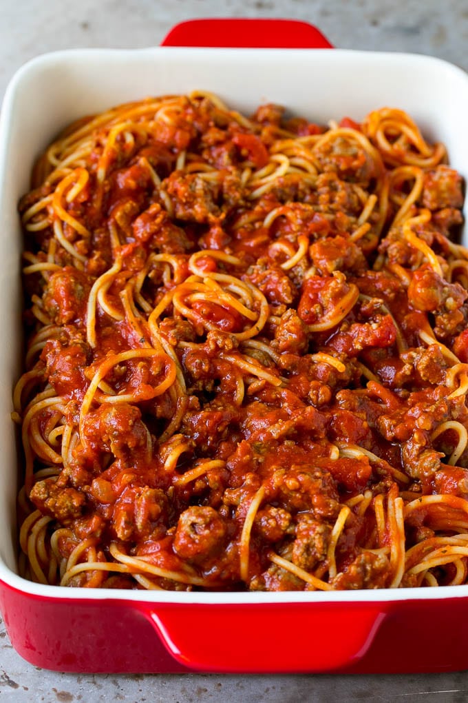 Espaguetis mezclados con salsa de carne en una fuente para horno.