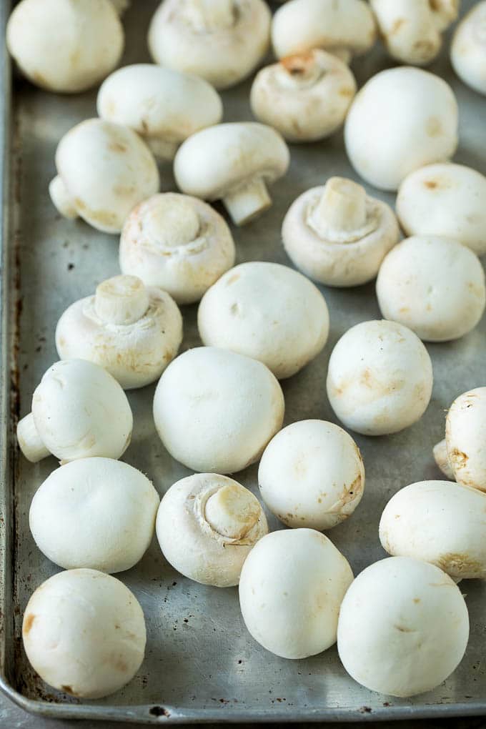Champiñones blancos en una bandeja para hornear.