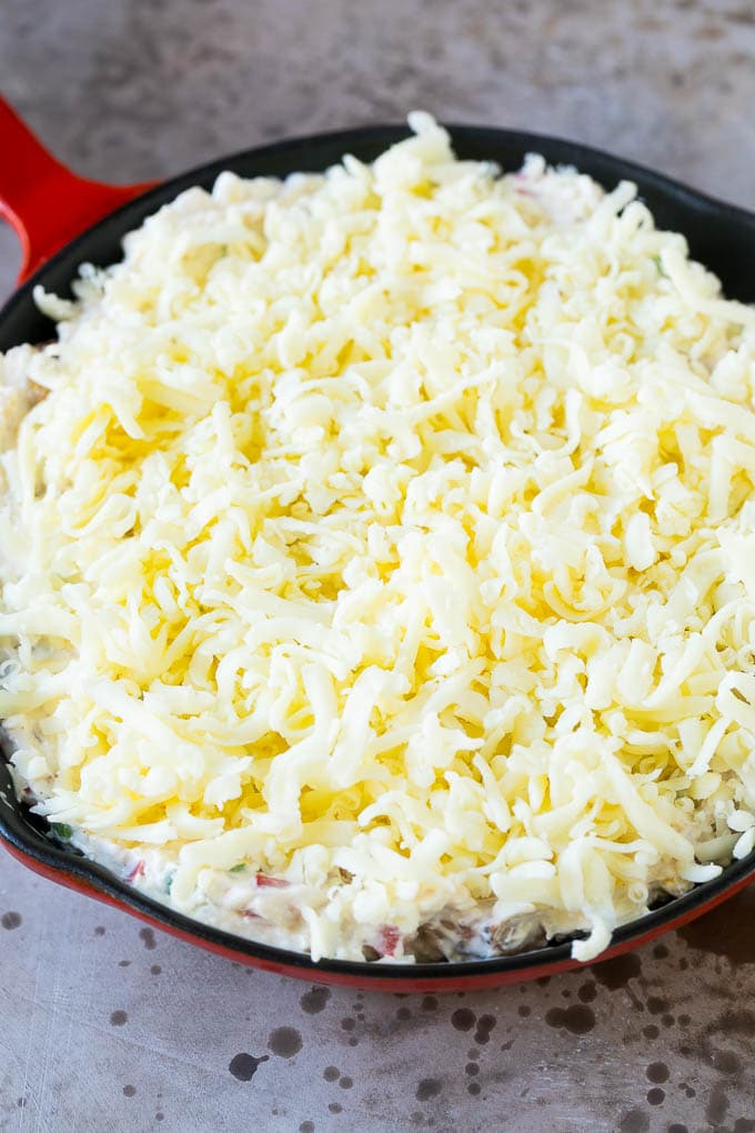 Una cacerola de salsa de camarones cubierta con una capa de queso rallado.