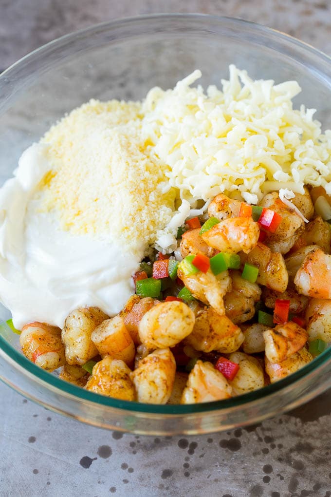 Camarones picados, pimientos, queso y crema agria en un bol.