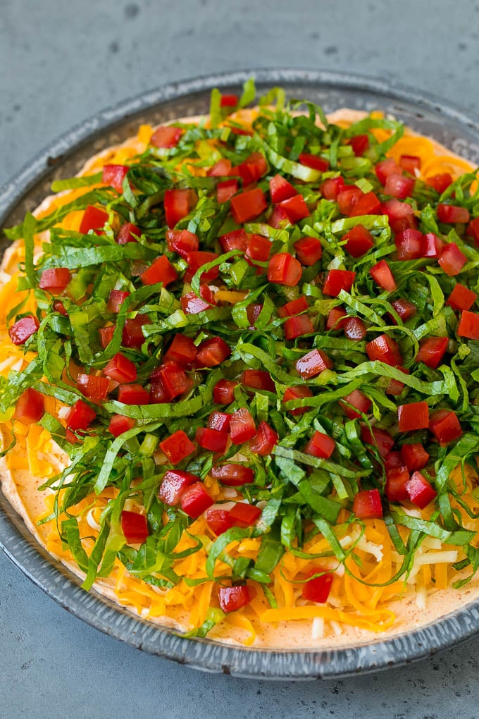 Lechuga y tomate sobre una base de queso rallado y salsa cremosa.