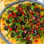Salsa de taco con capas de queso crema añejo, lechuga, tomate, queso rallado y aceitunas.