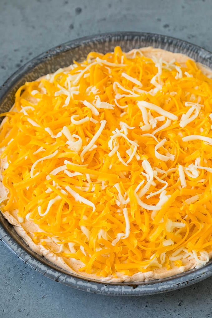 Queso rallado espolvoreado con queso crema con sabor a taco y crema agria.