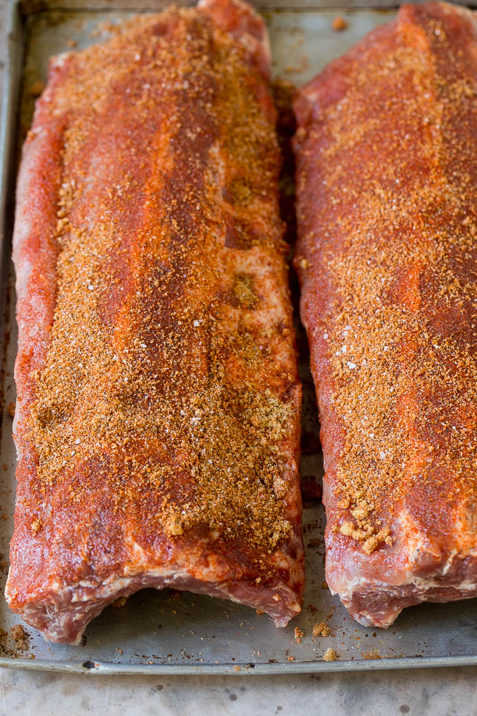 Receta de costillas ahumadas | Costillas posteriores | Costillas de cerdo # cerdo # costillas # fumador # cena #dinneratthezoo Dos estantes de costillas cubiertos de especias lavadas.