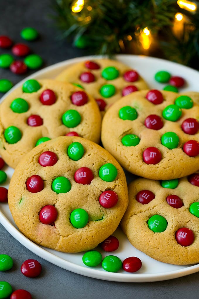 Un plato de galletas navideñas con M & Ms rojo y verde en su interior.