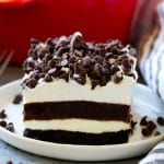 Una rebanada de lasaña de chocolate con capas de corteza de galleta, tarta de queso y pudín de chocolate.