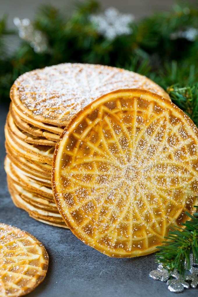 Una pila de pizzelle espolvoreada con azúcar en polvo.