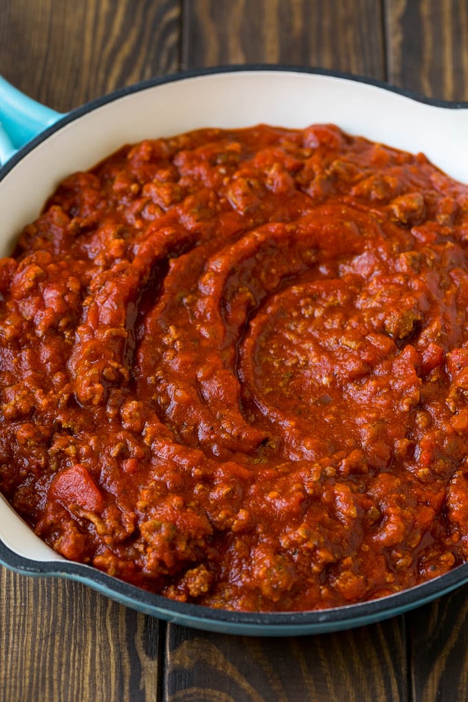 Salsa de carne con carne picada y tomates en una sartén.