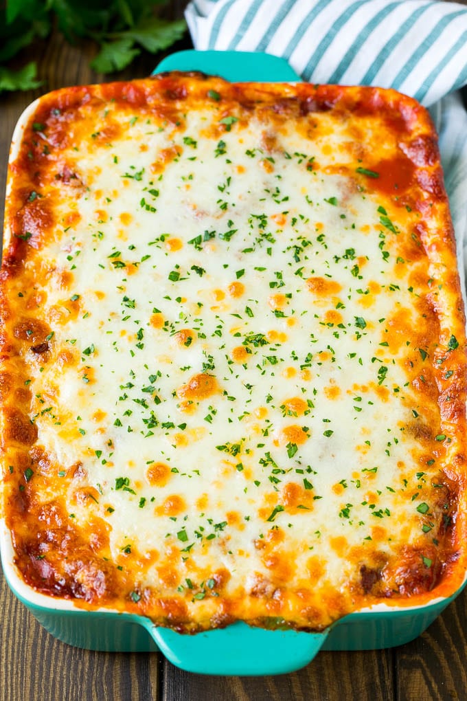 Una lasaña de calabacín al horno cubierta con queso derretido y perejil.