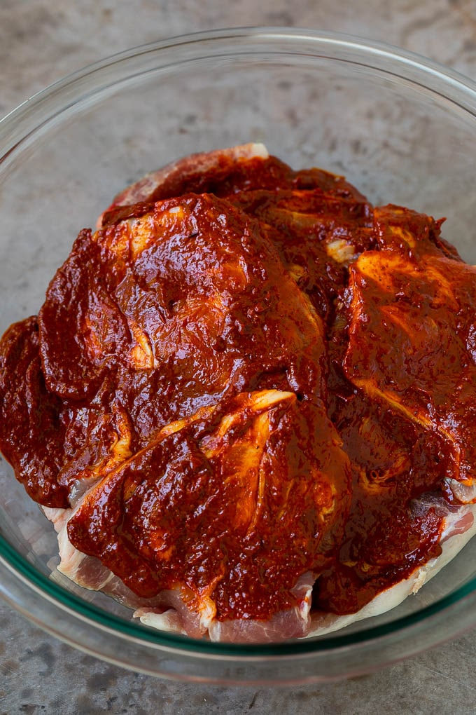 Paletilla de cerdo en rodajas cubierta con un adobo de ají.