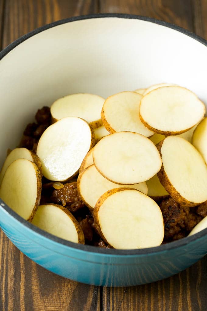 Rodajas de salchicha y patatas en una cacerola.