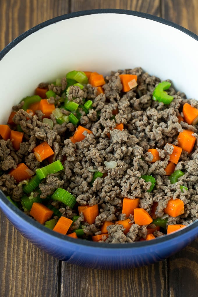 Carne molida, zanahorias, cebolla y apio en una tetera.