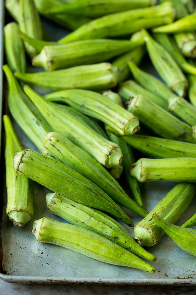 Receta de okra frita #okra #aperitif #sidedish #dinneratthezoo Vainas de quingombó en una bandeja para hornear.