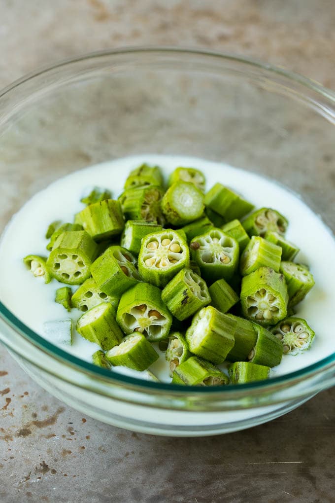 Receta de okra frita #okra #aperitif #sidedish #dinneratthezoo Rebanadas de okra en un tazón de suero de leche.