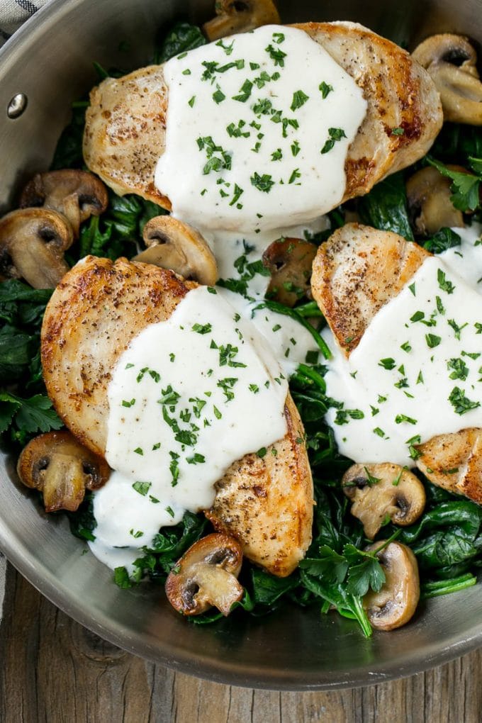 Esta receta de pollo a la florentina está hecha con pechugas de pollo doradas, cubierta con una salsa cremosa y servida sobre una cama de espinacas.  ¡Una cena clásica que te hará lamer el plato!