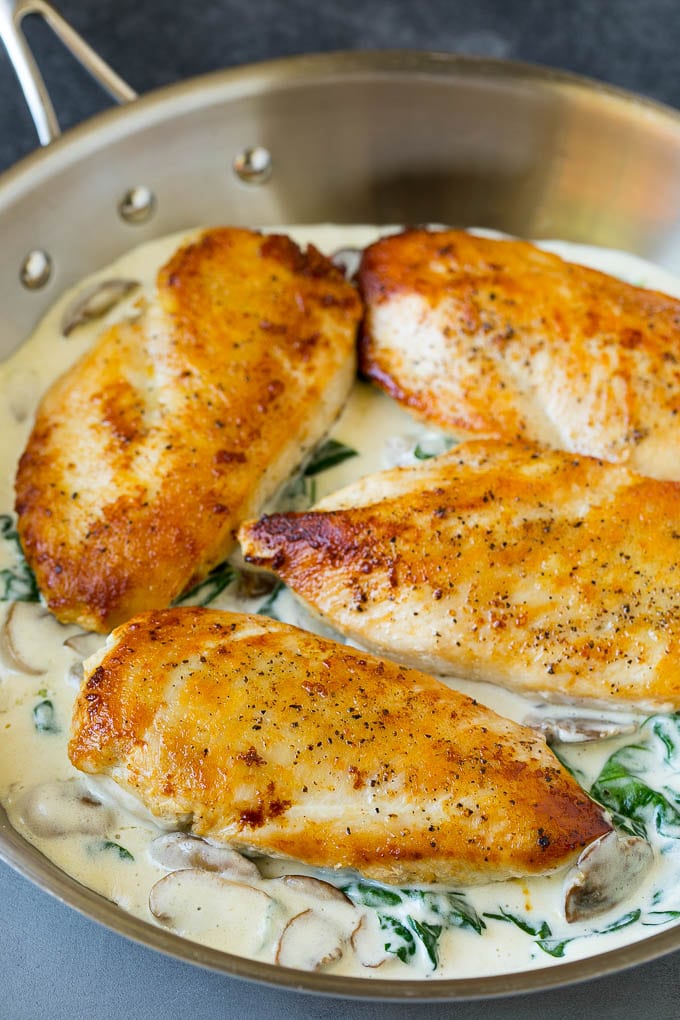 Pechugas de pollo cocidas en una cacerola con salsa de crema.