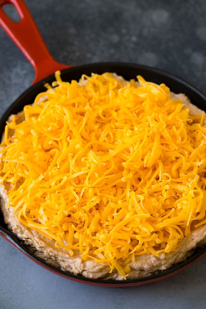 Frijoles cremosos cubiertos con queso rallado.
