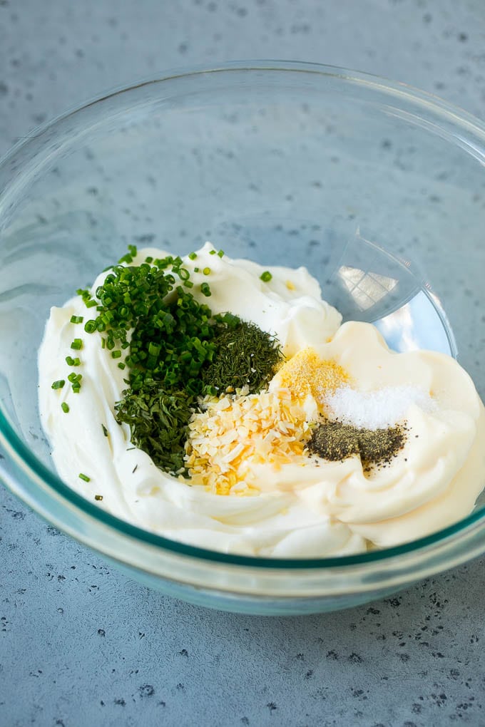 Crema agria, mayonesa, hierbas y especias en un bol.