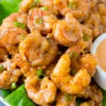 Camarones bang bang mezclados con una cremosa salsa de chile y servidos sobre lechuga.