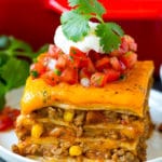 Una rebanada de lasaña mexicana hecha con capas de queso, tortillas y carne.