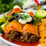 Un plato de enchiladas de ternera con crema agria, aceitunas y cebollas verdes.