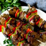 Shish kebab hecho con carne de res, pimientos y cebollas en un plato para servir.