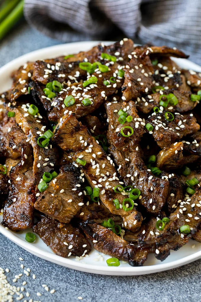 Un plato de bulgogi de ternera a la parrilla con guarnición de semillas de sésamo y cebollas verdes.