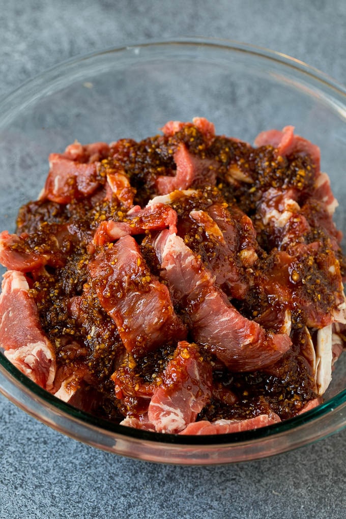 Tiras de solomillo en un cuenco de adobo.