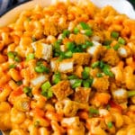 Macarrones con queso de pollo Buffalo con trozos de pollo crujientes, apio y salsa picante.