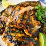 Muslos de pollo a la plancha en rodajas con cilantro y lima.