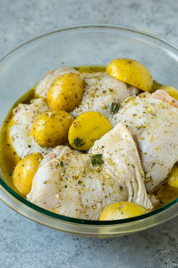 Muslos de pollo y patatas marinadas con ajo y hierbas.
