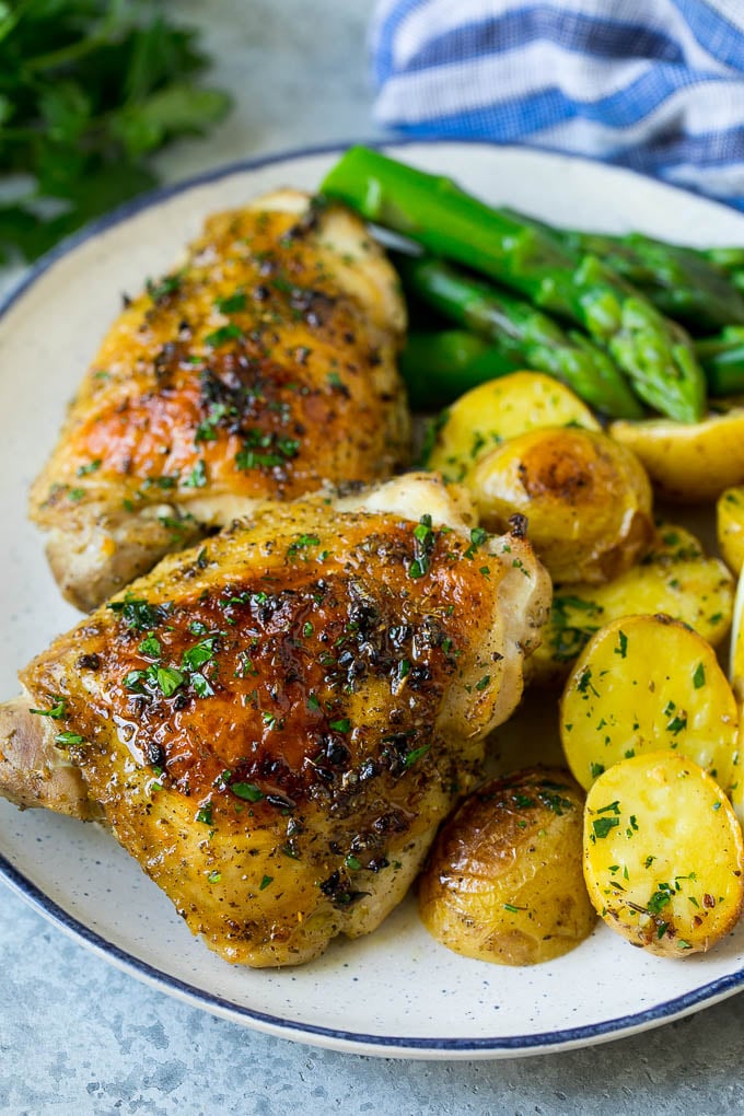 Pollo griego y patatas en un plato con espárragos.