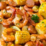 Hervir los camarones con camarones tiernos, mazorcas de maíz, papas y chorizo.
