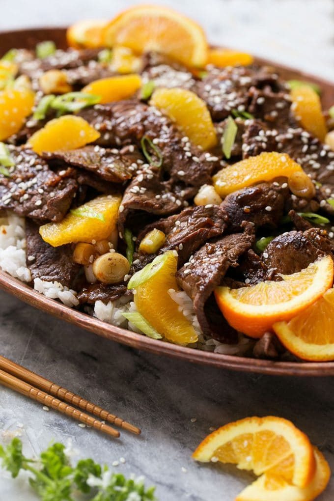 Un plato de ternera con salsa de naranja.