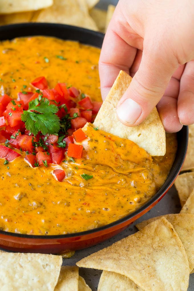 Receta Rotel Dip | Salsa de queso mexicano | Salsa de ternera y queso | Velveeta Dip #dip #aperitivo #hamburguesa #tomates #queso #dinneratthezoo Chip que recoge una porción de salsa Rotel.