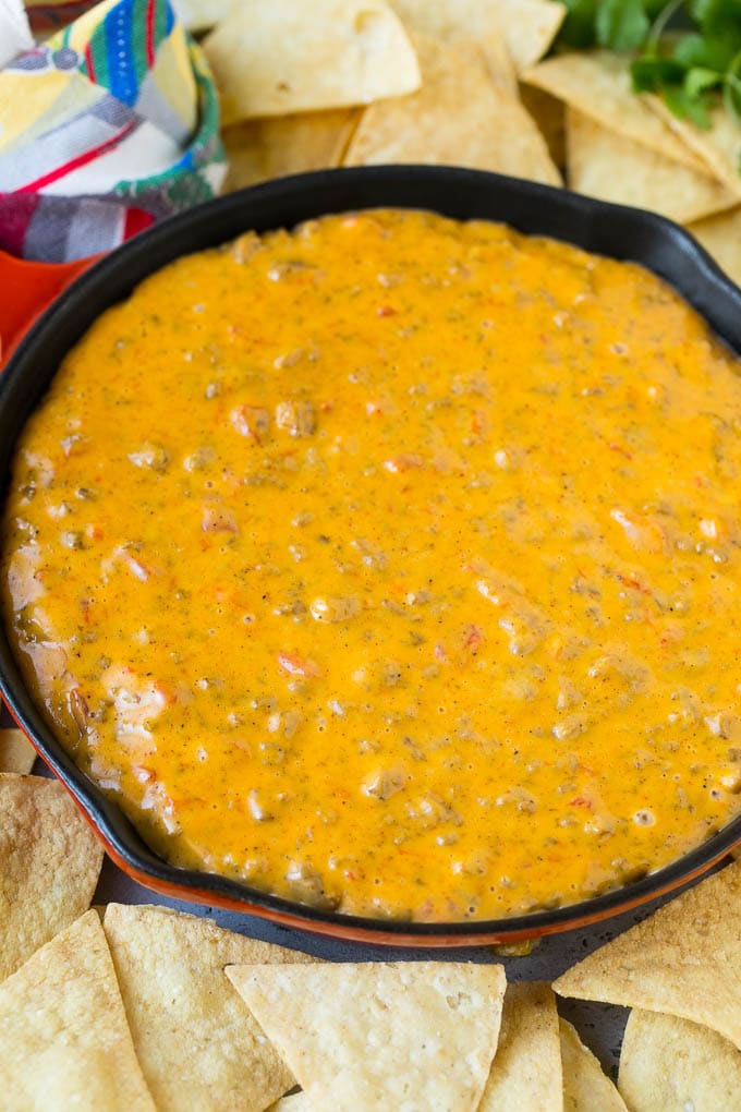 Receta Rotel Dip | Salsa de queso mexicano | Salsa de ternera y queso | Velveeta Dip #dip #aperitivo #hamburguesa #tomates #queso #dinneratthezoo Una cacerola de salsa Rotel rodeada de totopos.