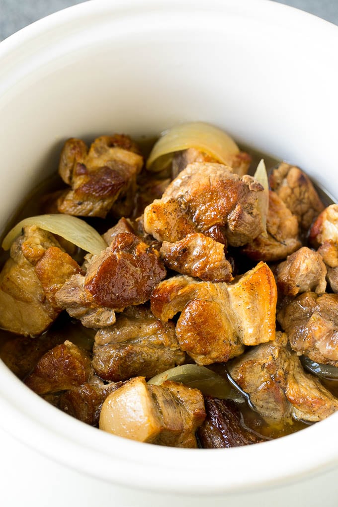 Receta de carnitas de taco de cocción lenta | Tacos de cerdo #tacos #pork # dinner #slowcooker #crockpot #dinneratthezoo Una olla de cocción lenta cubierta con carnitas de cerdo.