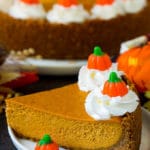 Una rebanada de tarta de queso de calabaza cubierta con crema batida.