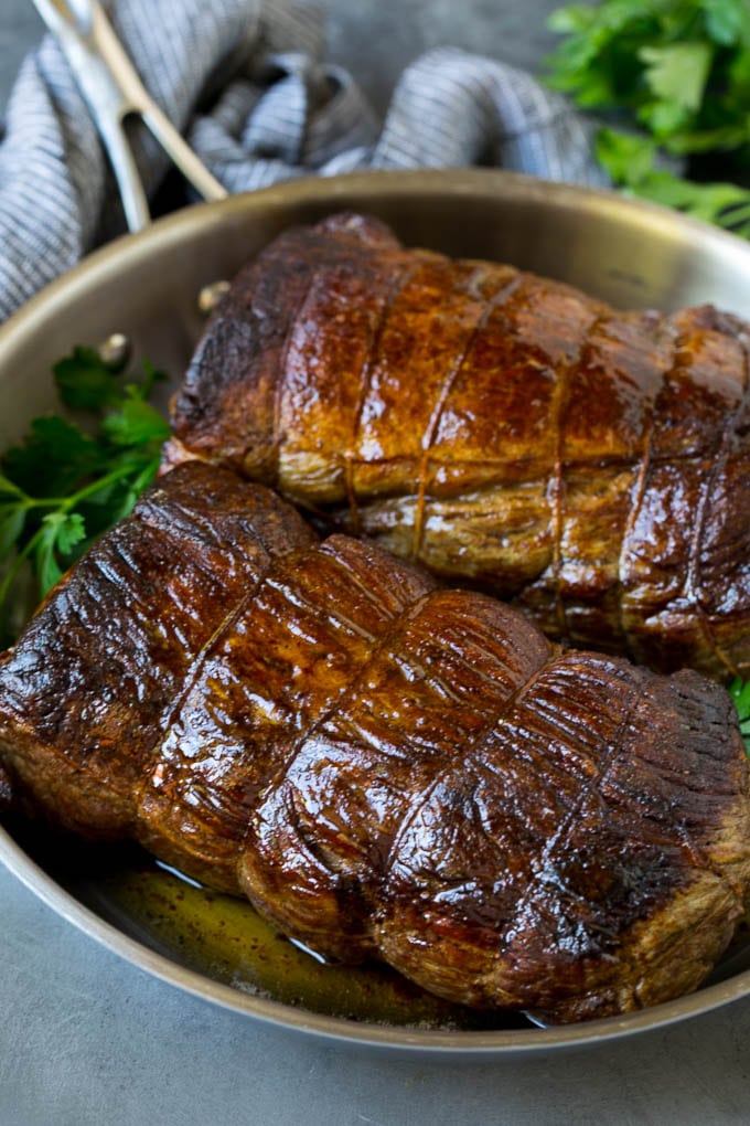 Filete de ternera en mantequilla con ajo asado en una sartén.