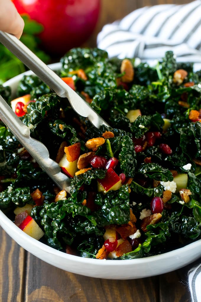 Pinzas en un cuenco de ensalada de col y manzanas.