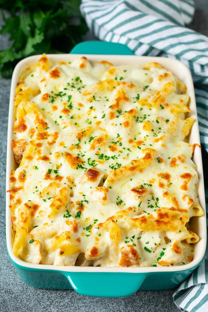 Pollo alfredo cocinado con penne en una salsa cremosa, cubierto con queso derretido.