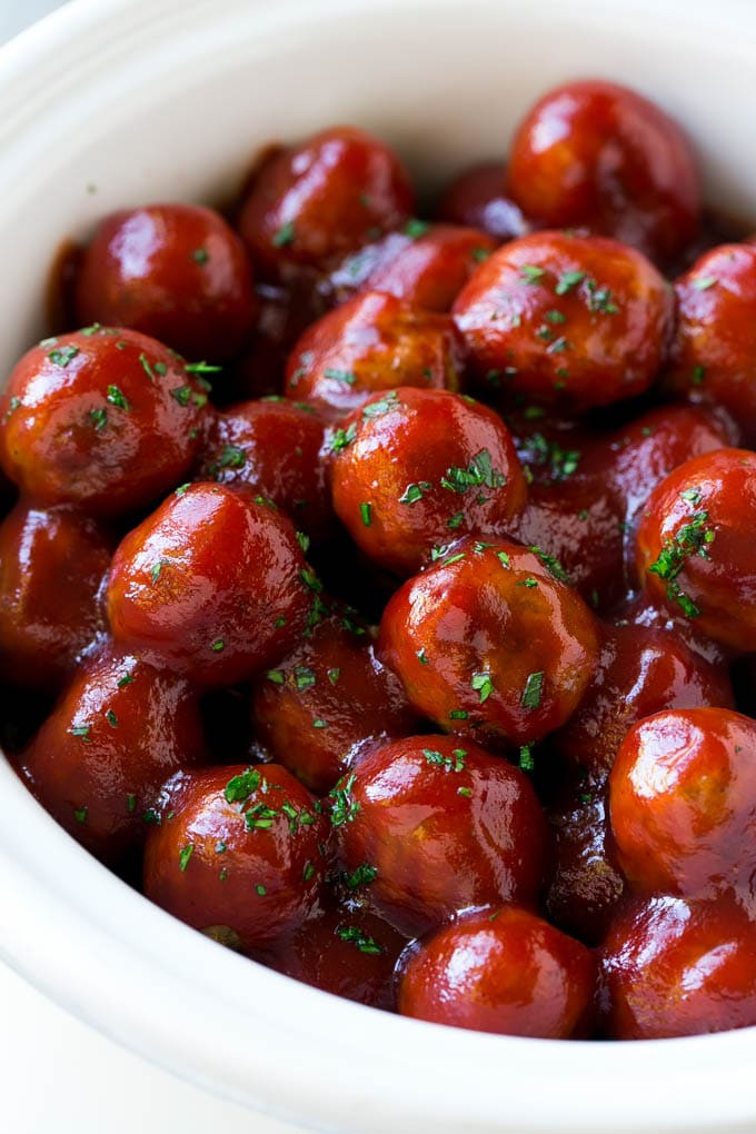 Receta de albóndigas de arándanos | Albóndigas cocidas a fuego lento | Aperitivo de cocción lenta | Crockpot albóndigas #meatballs #cranberry #slowcooker #crockpot #aperetizer #dinneratthezoo Albóndigas de arándano en una olla de cocción lenta cubiertas con perejil.
