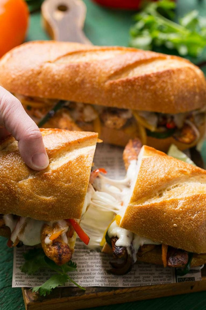 Estos sándwiches de pollo con fajita y cheesesteak están rellenos de pollo picante, pimientos y mucho queso, todo en un pan tostado.