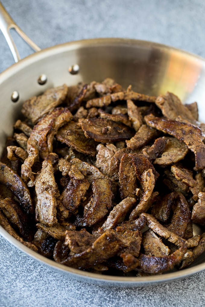 Bistec en rodajas finas en una sartén.